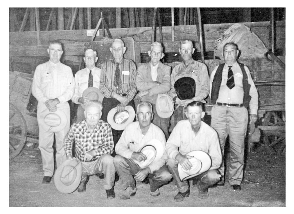 LASTWAGON Cowhands posing in front of the old Matador Ranch chuck wagon at the Burton-Lingo Lumberyard in Matador on Sept. 20, 1964, before it was donated to the Cowboy Hall of Fame were (back row, front right) Brooks Callaway, Albert J. Daffern, Virgil F. Leonard, Emmett H. Gafford, Melvin Dirickson and Ed. D. Smith (i.e., William Earl Smith); (kneeling, front row) Clarence C. Smauley, Walker Leonard and Rosie Deaton. | PHOTO #10536 BY JESS COUCH, MOTLEY COUNTY MUSEUM