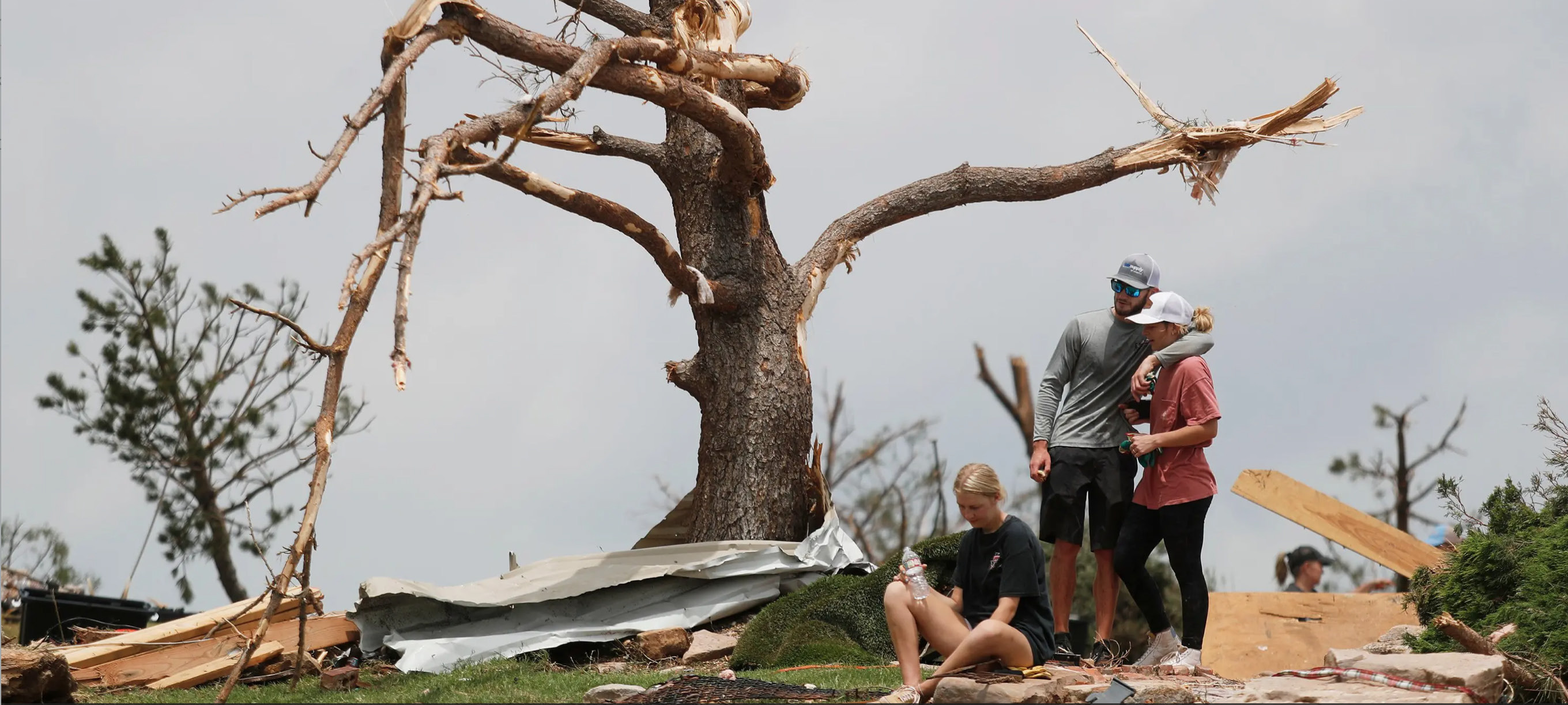 MARSHALINGSTRENGTH From left:Tyne Marshall sits on the ground next to Brett Homer and Cambrie Marshall, granddaughters of Ken and Mary Marshall, who survived the tornado that struck the small town of Matador on June 21, 2023. | MARK ROGERS FOR THE TEXAS TRIBUNE