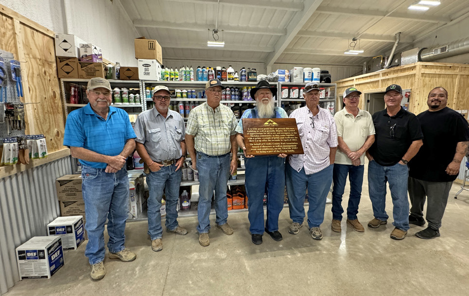 PRIDE AND RESILIENCE are celebrated in the text of the large, custom-made wooden plaque presented to the Crosby County Fuel Association’s McAdoo location last Friday by general manager Steve Riley. From left, board members Bobby Binder, Dusty Cornelius, Joe Mark Cargile, Mack Gardner (with plaque), Mark Schoepf, Brad Aycock and Russ Edinburgh, and store manager Luis Guzman. | THE TEXAS SPUR