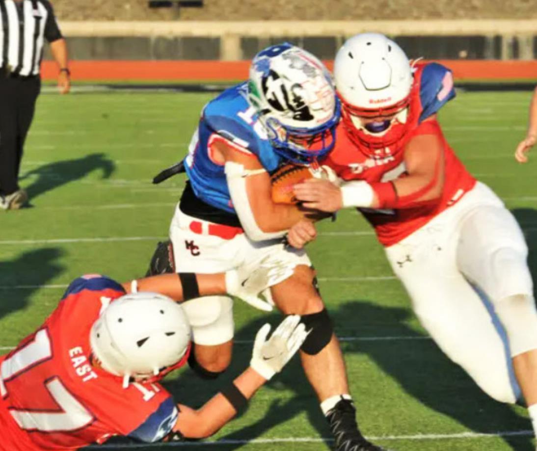 MOTLEY ALL-STAR Motley County's Kason Degan (blue) is tackled by two East defenders during the Texas Six Man Coaches Association All-Star DII football game in Iowa Park on Saturday, July 16. | COURTESY PHOTO