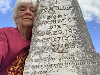 Snuggling last week against her great-grandfather’s tombstone in Pilot Point, Texas, is columnist Hanaba Munn Welch, who took the selfie. Deciphering the script proved challenging. Finding its origin tested Artificial Intelligence. | HANABA MUNN WELCH
