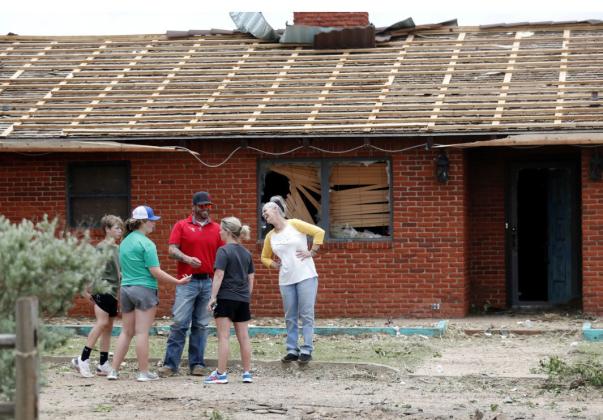 RESILIENT Matador townspeople laugh despite the devastation outside of Nicki Dempsey’s home on Thursday, June 22, 2013, after a tornado devastated the small town Wednesday night. | MARK ROGERS FOR THE TEXAS TRIBUNE