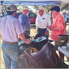 VINTAGE VIEW From left, Tanner Reynolds, Ben Grundy, J.N. Fletcher and Mike Schweitzer checked out details on the vintage saddles on display during Old Settlers, Aug 24–26, 2023. | COURTESY PHOTO