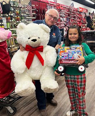 CHRISTMAS WINNER Ariel Rodriquez of Paducah was the winner of theTeddy bear and fun-filled wagon from Plains Lumber. Her name was drawn during a holiday celebration Friday, Dec. 22. Store manager Glynn Willis celebrates with Ariel. | COURTESY PHOTO