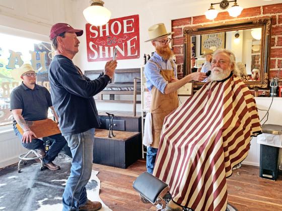 TURKEYBEARD Austen Covin trimsWylie Bomar’s beard Saturday at the historic Ham’s Barber Shop in Turkey, where Bob Wills once gave shaves and haircuts. Snapping a picture is owner Mike Goldsby; taking a break is the shoeshine boy, Josh Kreusel. Shaves, haircuts, shoeshines and tours of the refurbished building were free on Saturday, compliments of Goldsby. Reporterphotographer Hanaba Munn Welch is visible in the bottom right corner of the mirror. SEE SPOTLIGHT PHOTOS, PAGE 10 | HANABA MUNNWELCH