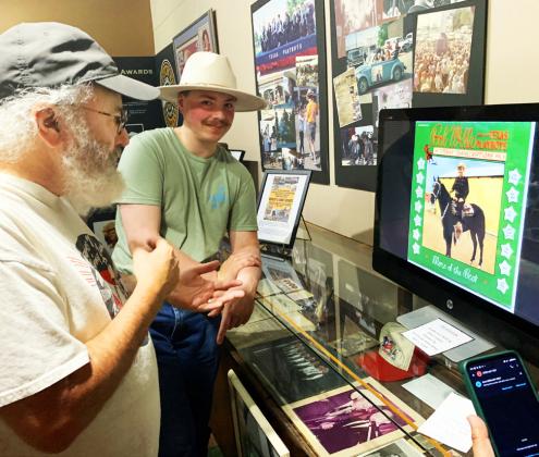 MUSIC MONITOR Saxophonist Constantine Daniels listens Friday to researcher Rob Graves as he tells about the many ways he gathered Bob Wills recordings—a comprehensive collection accessible via a computer monitor set up in “kiosk” mode at the Bob Wills Museum in Turkey. His right-hand supporter, his wife Anna Graves, is holding the phone, bottom right. | HANABA MUNN WELCH