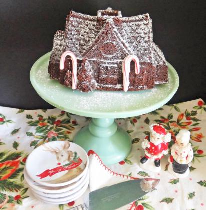 GINGERBREAD HOME FOR THE HOLIDAYS A tall, glass cake plate dome placed over a gingerbread house will help reserve its freshness for the season. | ANGELINA LARUE