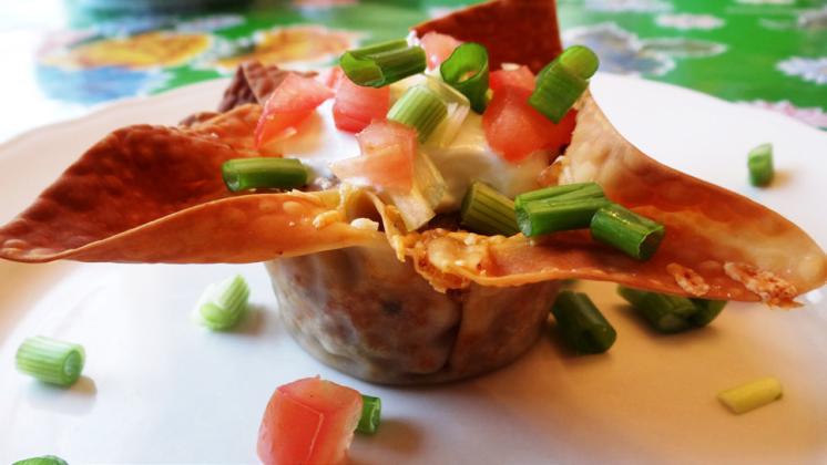 PARTY PREP Taco cups in muffin tins can be created by brushing egg-roll or wonton wrappers with oil to crisp in the oven, eliminatingtheneedtofordeepfrying. | ANGELINALaRUEPHOTO