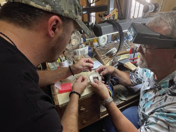 FINESSE Craftsmen James Sanders (left) and Kelly Keitz are among those who custom-design and produce rings, buckles, and many other items at the Roaring Springs factory. | CAPROCK COURIER