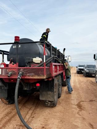 Firefighter Jamie Plumlee waits for the TVFD tanker operator to finish refilling their truck before returning to action.