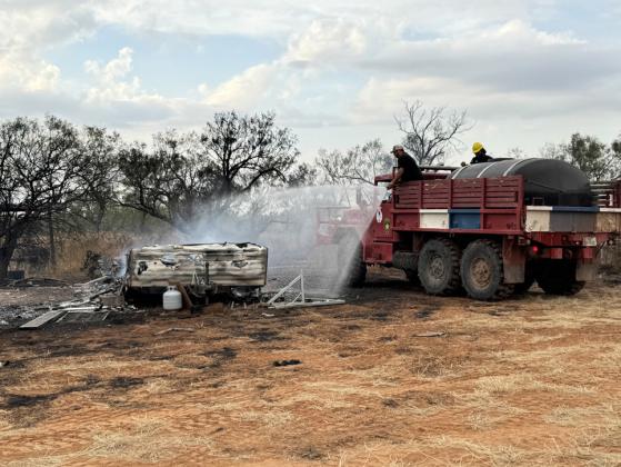 Braden Byers cools off a still smoldering camper fromTVFD Brush 2