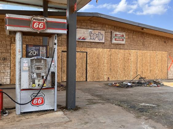 Glass display windows and doors of the Hop In convenience store on US Hwy. 70 and Texas Hey. 70 were boarded up in advance of cleanup efforts.