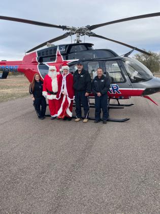 LIFESTAR 4 CREW AND THE CLAUSES posed before taking off to meet the children at Christmas in the Valley in Turkey on Saturday, Dec. 7. From left: flight paramedic Kodie Fairchild; Santa Claus, Mrs. Claus; pilot Richard Alexander and flight nurse Paul Nombrano.