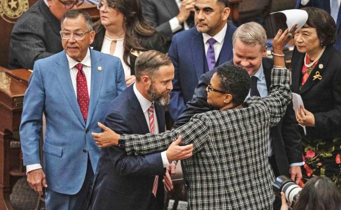 ACROSS THE AISLE State Rep. Toni Rose (D-Dallas) hugs fellow Reps. Dustin Burrows (R-Lubbock) and David Cook (R-Mansfield) after Burrows won the vote for speaker Jan. 14. | ELI HARTMAN/THE TEXAS TRIBUNE