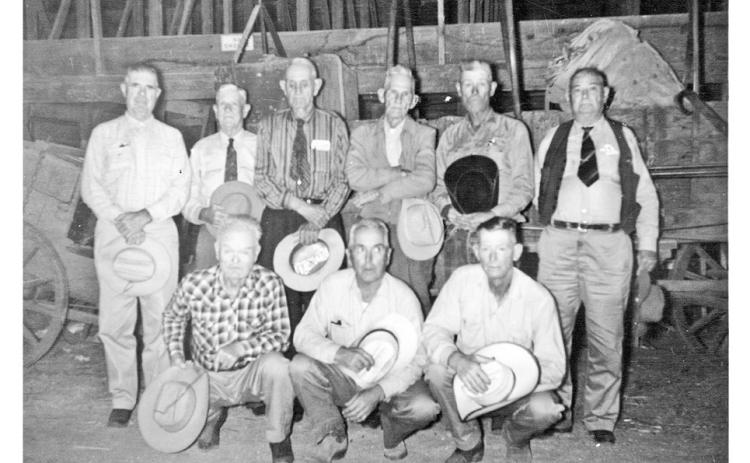 LASTWAGON Cowhands posing in front of the old Matador Ranch chuck wagon at the Burton-Lingo Lumberyard in Matador on Sept. 20, 1964, before it was donated to the Cowboy Hall of Fame were (back row, front right) Brooks Callaway, Albert J. Daffern, Virgil F. Leonard, Emmett H. Gafford, Melvin Dirickson and Ed. D. Smith (i.e., William Earl Smith); (kneeling, front row) Clarence C. Smauley, Walker Leonard and Rosie Deaton. | PHOTO #10536 BY JESS COUCH, MOTLEY COUNTY MUSEUM