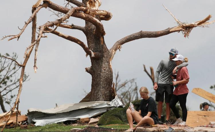 MARSHALINGSTRENGTH From left:Tyne Marshall sits on the ground next to Brett Homer and Cambrie Marshall, granddaughters of Ken and Mary Marshall, who survived the tornado that struck the small town of Matador on June 21, 2023. | MARK ROGERS FOR THE TEXAS TRIBUNE