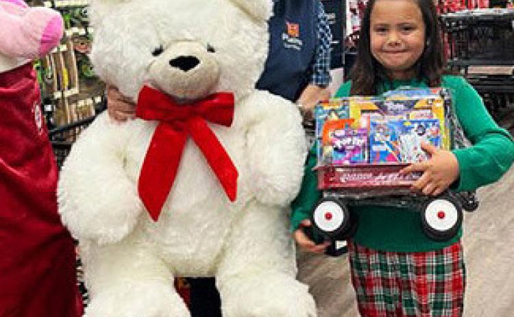 CHRISTMAS WINNER Ariel Rodriquez of Paducah was the winner of theTeddy bear and fun-filled wagon from Plains Lumber. Her name was drawn during a holiday celebration Friday, Dec. 22. Store manager Glynn Willis celebrates with Ariel. | COURTESY PHOTO