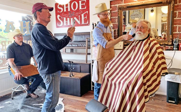 TURKEYBEARD Austen Covin trimsWylie Bomar’s beard Saturday at the historic Ham’s Barber Shop in Turkey, where Bob Wills once gave shaves and haircuts. Snapping a picture is owner Mike Goldsby; taking a break is the shoeshine boy, Josh Kreusel. Shaves, haircuts, shoeshines and tours of the refurbished building were free on Saturday, compliments of Goldsby. Reporterphotographer Hanaba Munn Welch is visible in the bottom right corner of the mirror. SEE SPOTLIGHT PHOTOS, PAGE 10 | HANABA MUNNWELCH