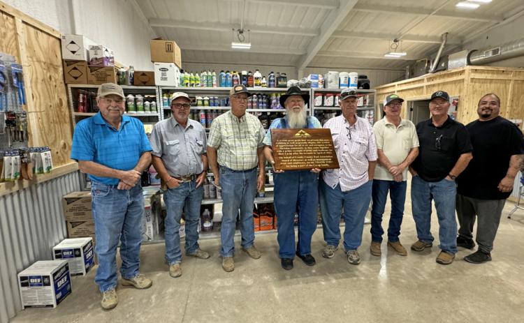 PRIDE AND RESILIENCE are celebrated in the text of the large, custom-made wooden plaque presented to the Crosby County Fuel Association’s McAdoo location last Friday by general manager Steve Riley. From left, board members Bobby Binder, Dusty Cornelius, Joe Mark Cargile, Mack Gardner (with plaque), Mark Schoepf, Brad Aycock and Russ Edinburgh, and store manager Luis Guzman. | THE TEXAS SPUR