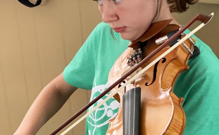 YOUNG FIDDLER Romie Hinshaw practices her bow technique at the annual BAM Music Camp in Turkey this week. | HANABA MUNNWELCH