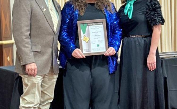 GOLD STAR Makenlee Lemons of Quitaque (at center between 4-H presenters Josh Brooks andTina Bryant) has earned 4-H’s Gold Star award. | COURTESY PHOTOS