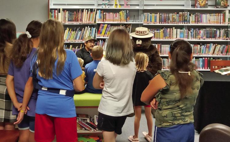 Texas A&M Forest Service and Smoky the Bear visited with youngsters at the Caprock Library in Quitaque earlier this month for their summer reading program. | COURTESY PHOTOS