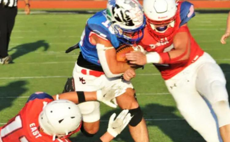MOTLEY ALL-STAR Motley County's Kason Degan (blue) is tackled by two East defenders during the Texas Six Man Coaches Association All-Star DII football game in Iowa Park on Saturday, July 16. | COURTESY PHOTO