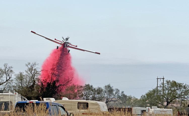 FIREFIGHTING FROM GROUND AND AIR A Texas A&amp;M Forest Service plane dropped retardant along the northeast fire line of last Friday’s hunting camp fire outside Turkey, Texas. MORE PHOTOS, PAGE 10 | KODIE FAIRCHILD