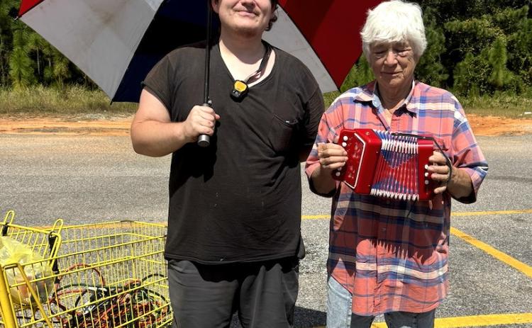 MARKETPLACE GURU DARIUS and his customer Hanaba as they prepare to sing a song in the Dollar General parking lot. | PHOTO BY TERRI DRAKE